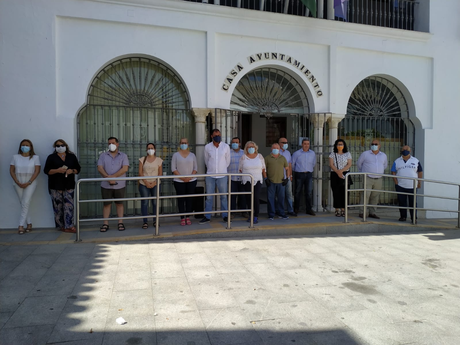 En la foto, varios delegados del Equipo de Gobierno, concejales de Adelante Sanlúcar Avanza, trabajadores/as municipales y el Presidente de la Hermandad del Rocío, durante el minuto de silencio guardado esta mañana a las puertas del Ayuntamiento.